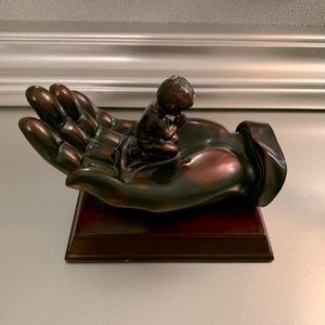 Bronze boy praying in hand